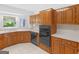 Well-lit kitchen featuring wooden cabinets, white countertops, and black appliances against a tiled floor at 114 Overlook Dr, Mcdonough, GA 30252