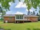 Rear of home showing brick exterior, and large back yard with partially covered deck at 114 Overlook Dr, Mcdonough, GA 30252
