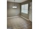Open dining room with a modern chandelier, tile floors, neutral walls, and natural light from the window at 1321 Lakeview Nw Dr, Conyers, GA 30012