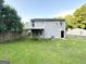Backyard view showcasing a deck, grassy area, and partial fence surrounding property at 3170 W Point Cir, Douglasville, GA 30135