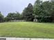 Green backyard view with a wooden fence and a small storage shed at 1031 Jordan Rd, Dacula, GA 30019