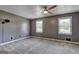 Carpeted bedroom featuring a ceiling fan, neutral paint, and two windows for natural light at 108 Country Acres Ct, Mcdonough, GA 30253