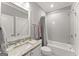 Bright bathroom featuring a granite countertop, white vanity, and subway tile shower over tub at 1104 Victoria Ne St, Atlanta, GA 30319