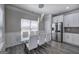 Elegant dining area with a glass table, white chairs, modern lighting, and stainless fridge at 158 Bryon Ln, Acworth, GA 30102