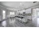 Open-concept living space with kitchen island, stainless appliances, and dining area with modern light fixture at 158 Bryon Ln, Acworth, GA 30102