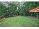 Large backyard with lush green grass, firepit, and perimeter of mature trees at 123 Mill, Dallas, GA 30157