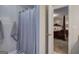 Bathroom with shower and gray tile flooring adjacent to open main bedroom with dark wood furniture at 123 Mill, Dallas, GA 30157