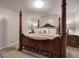 Bedroom with a four poster bed with neutral colored bedding and decor at 123 Mill, Dallas, GA 30157