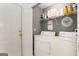 Laundry room with white washer and dryer and shelving for storage at 1765 Neighborhood Walk, Mcdonough, GA 30252