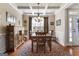 This dining room has a wooden table with neutral colored chairs, a chandelier, and a patterned rug at 409 Brandy Ln, Mcdonough, GA 30253