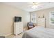 Neutral bedroom featuring a dresser, tv, a ceiling fan, carpet and a chair at 1386 Sheffield Glen Ne Way, Atlanta, GA 30329