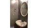 Powder room with pedestal sink, oval mirror, and neutral wall color at 5658 Wind Gate Ln, Lithonia, GA 30058