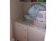 Compact laundry area with white stacked washer and dryer at 5658 Wind Gate Ln, Lithonia, GA 30058