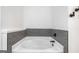 Clean, white bathroom with a modern tub and stylish gray tile at 5745 Westwood Dr, Cumming, GA 30040