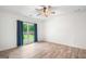 Bedroom with wood-look floors and a window overlooking a lush backyard at 5745 Westwood Dr, Cumming, GA 30040