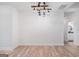 Dining room with rustic chandelier, white walls, and luxury vinyl plank flooring with a bathroom in background at 5745 Westwood Dr, Cumming, GA 30040