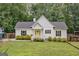 Charming home featuring a bright yellow door, black shutters, manicured landscaping, and a lush green lawn at 5745 Westwood Dr, Cumming, GA 30040