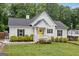 Charming home featuring a bright yellow door, black shutters, manicured landscaping, and a lush green lawn at 5745 Westwood Dr, Cumming, GA 30040