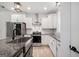 Kitchen featuring white cabinets, granite countertops, stainless steel appliances, and a farmhouse sink at 5745 Westwood Dr, Cumming, GA 30040