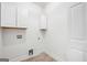 Bright laundry room featuring white cabinets, wood-look flooring, and utility connections, perfect for convenience at 5745 Westwood Dr, Cumming, GA 30040