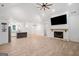 Open-concept living area with fireplace, wood floors, and modern kitchen at 5745 Westwood Dr, Cumming, GA 30040