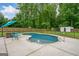 Backyard pool with fence, lounge chairs, and surrounding greenery at 5745 Westwood Dr, Cumming, GA 30040