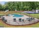 Backyard pool area is surrounded by a fence and green trees at 5745 Westwood Dr, Cumming, GA 30040