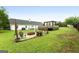Expansive backyard featuring a fire pit area, wooden deck with a pergola, and lush green lawn at 1195 New Hope Rd, Locust Grove, GA 30248
