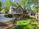View of the backyard featuring a spacious lawn, mature trees, and a charming picket fence at 4680 Brighton Lake Dr, Cumming, GA 30040