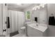 Bright bathroom featuring a tub with shower, window and a white single sink vanity at 4680 Brighton Lake Dr, Cumming, GA 30040