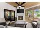 Inviting sunroom featuring a fireplace, comfortable seating, ceiling fan, and doors to the outdoors at 4680 Brighton Lake Dr, Cumming, GA 30040