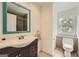 Bathroom features a blue framed mirror, and a toilet and vanity with neutral tile flooring at 5940 Plantation Dr, Roswell, GA 30075