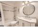 Bathroom with a marble vanity, a round mirror and shower with white tiles at 5940 Plantation Dr, Roswell, GA 30075