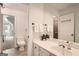 Bright bathroom featuring a white vanity, large mirror, and a view into an adjacent bedroom, offering functionality at 5940 Plantation Dr, Roswell, GA 30075