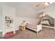 Bright bedroom with sloped ceilings, a bed, reading nook and books on shelves at 5940 Plantation Dr, Roswell, GA 30075