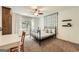 Bright bedroom with neutral decor, a black metal frame bed, desk and a ceiling fan at 5940 Plantation Dr, Roswell, GA 30075