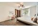 Bright bedroom with a desk and chair, a bed with a metal frame and neutral decor at 5940 Plantation Dr, Roswell, GA 30075
