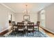 Formal dining room with hardwood floors, classic chandelier, and window views at 5940 Plantation Dr, Roswell, GA 30075