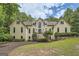 Stately two-story home featuring manicured landscaping and a symmetrical facade with arched windows at 5940 Plantation Dr, Roswell, GA 30075
