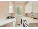 Functional laundry room featuring a sink, ample counter space, washer, and dryer, making chores a breeze at 5940 Plantation Dr, Roswell, GA 30075