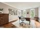 Well-lit home office with hardwood floors, vintage cabinet and arched windows at 5940 Plantation Dr, Roswell, GA 30075