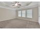 Spacious primary bedroom with a tray ceiling, plush carpet, and natural light at 1300 Hopkins Dr, Decatur, GA 30033