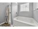 Bathroom showcasing a modern tub with shower, window, and neutral colored shower curtain at 1535 Fenmore St, Lithia Springs, GA 30122