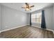 Bright bedroom with a ceiling fan, a large window with blue drapes, and wood-look laminate flooring at 1535 Fenmore St, Lithia Springs, GA 30122