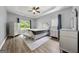 Bright bedroom boasts hardwood flooring, neutral paint, and a tray ceiling with fan at 1535 Fenmore St, Lithia Springs, GA 30122