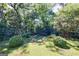 A gorgeous green backyard, landscaped with bushes, a brick border, and a fire pit at 381 Cherokee Se Ave, Atlanta, GA 30312