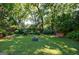 Spacious backyard with mature trees, lush landscaping, a firepit, and a bench at 381 Cherokee Se Ave, Atlanta, GA 30312