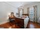 Bright bedroom with hardwood floors, chandelier, and floral curtains with vintage dressing table at 381 Cherokee Se Ave, Atlanta, GA 30312
