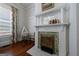 Elegant fireplace with a decorated mantel and tiled accents, alongside a window and bassinet at 381 Cherokee Se Ave, Atlanta, GA 30312