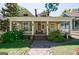 Charming yellow home featuring a spacious front porch with white columns and a red front door at 381 Cherokee Se Ave, Atlanta, GA 30312